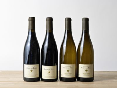 trois bouteilles de vin sont alignées sur une table en bois