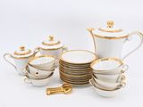 a white and gold tea set with cups and saucers