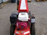 a red lawn mower parked in a parking lot