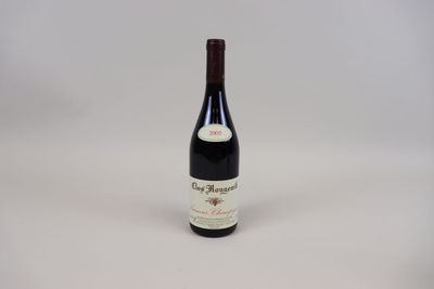 une bouteille de vin rouge posée sur une table blanche