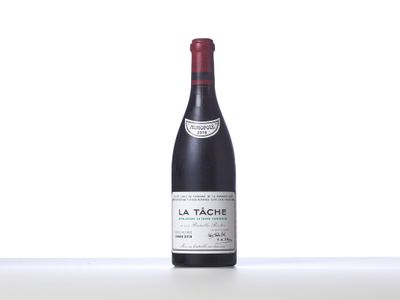 a bottle of red wine sitting on top of a white table