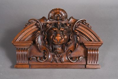 une image représentant une sculpture en bois représentant un lion, surmontée d'une tête de lion