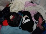 une pile de vêtements sur un lit dans une pièce