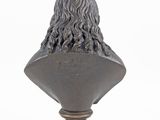 a bronze bust of a man with long hair on a pedestal