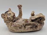 a figurine of a cat that is laying on its back