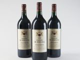 three bottles of red wine sitting next to each other on a white surface