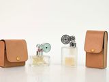 trois petits flacons de parfum et un étui posés sur la table