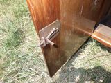 une porte en bois munie d'un loquet métallique