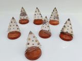 six small white christmas trees with brown bases on a white surface