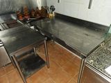 stainless steel work tables in a commercial kitchen with pots and pans on the counter