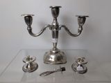 a silver candelab with three candles on a clear table