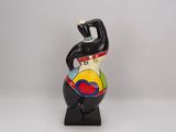 ceramic figurine of a woman with a hat on her head
