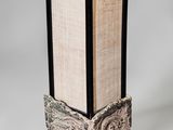 un grand vase avec un socle en bois, dans lequel se trouve un livre