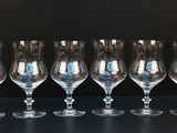 six empty wine glasses lined up on a table