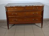 a marble top chest of drawers in the corner of a room