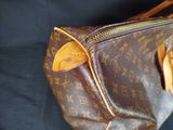 a close up of a louis vuitton bag on a black background
