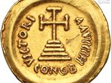 a close up of a gold coin with a cross on it