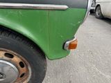 a close up of a green and black truck parked on the street