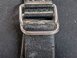 a close up of a black belt with a metal buckle