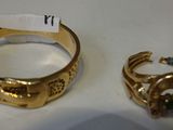 un gros plan sur une bague en or et une bague sertie d'une pierre verte