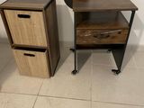 a small table with two drawers next to a chair