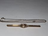 a silver and gold tie bar and a silver and gold tie bar
