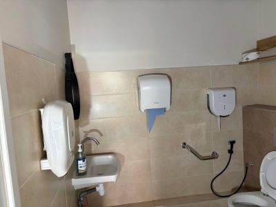 a bathroom with a toilet, sink, and hand dryer in it