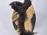 a black and gold hat with a black feather on it