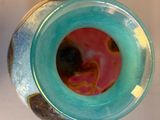 a blue vase with a pink and yellow design on it