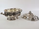two silverplated dishes with lids on a white surface
