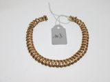 a gold chain bracelet with a price tag on it