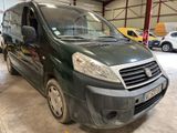 La camionnette verte est garée dans un garage avec d'autres voitures.