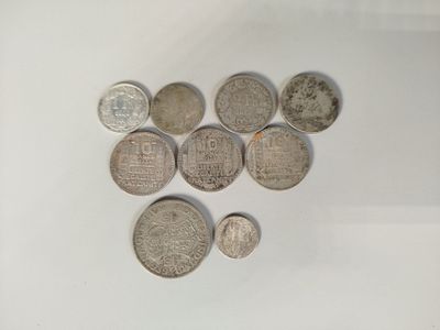 several coins are arranged in a heart shape on a white surface