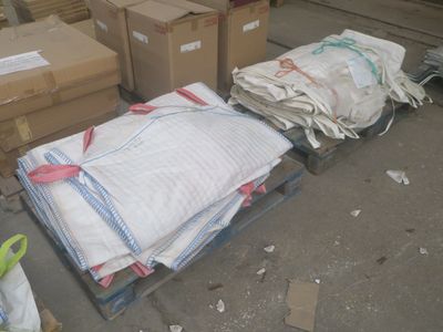 une palette sur laquelle sont empilés de nombreux sacs et cartons
