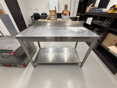 une table de travail en acier inoxydable équipée d'une étagère