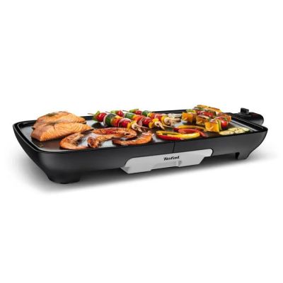 une photo d'un barbecue électrique sur lequel sont disposés de la viande et des légumes