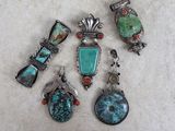 five pieces of turquoise and coral jewelry on a white surface