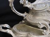 a silver serving dish with a handle on a table