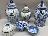 Plusieurs vases et bols bleus et blancs sont posés sur une table