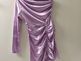 une robe violette à manches longues suspendue à un cintre contre un mur