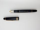 a close up of a pen and a ballpoint pen on a white surface