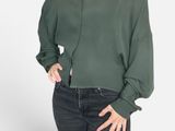 the woman is wearing a green shirt and jeans posing for a picture