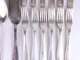 a lot of forks and spoons that are on the table