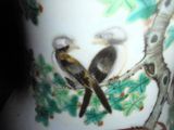 two birds sitting on a tree branch in a vase