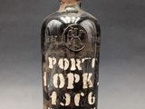 an old bottle of liquor with a cork stopper sitting on a table