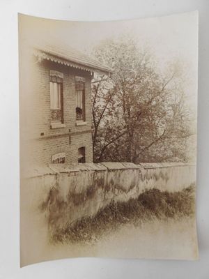 an old photo of an old building with a tree in front of it