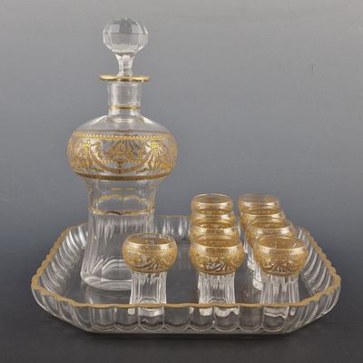 un service à vin ancien en verre, composé de six verres et d'une carafe, présenté sur un plateau