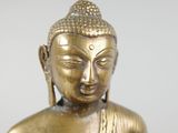 statue of a golden buddha with his eyes closed on a white background