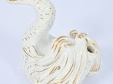 white ceramic figurine of a bird on a white background