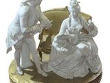 une figurine représentant un homme et une femme assis sur une chaise